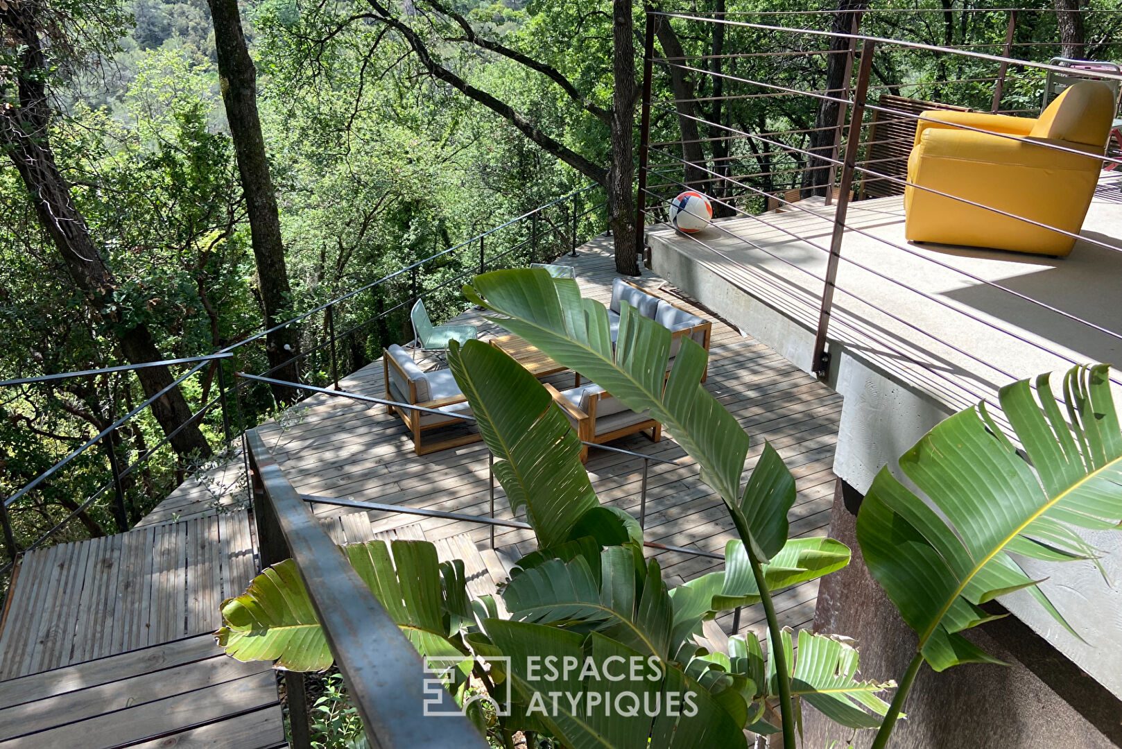 Brutalist house with wooden terrace in the middle of the forest
