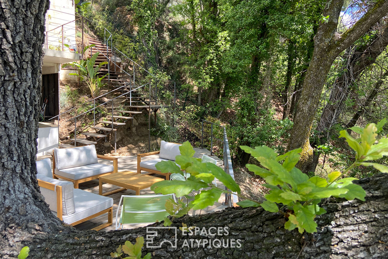 Maison brutaliste avec terrasse en bois au milieu de la forêt