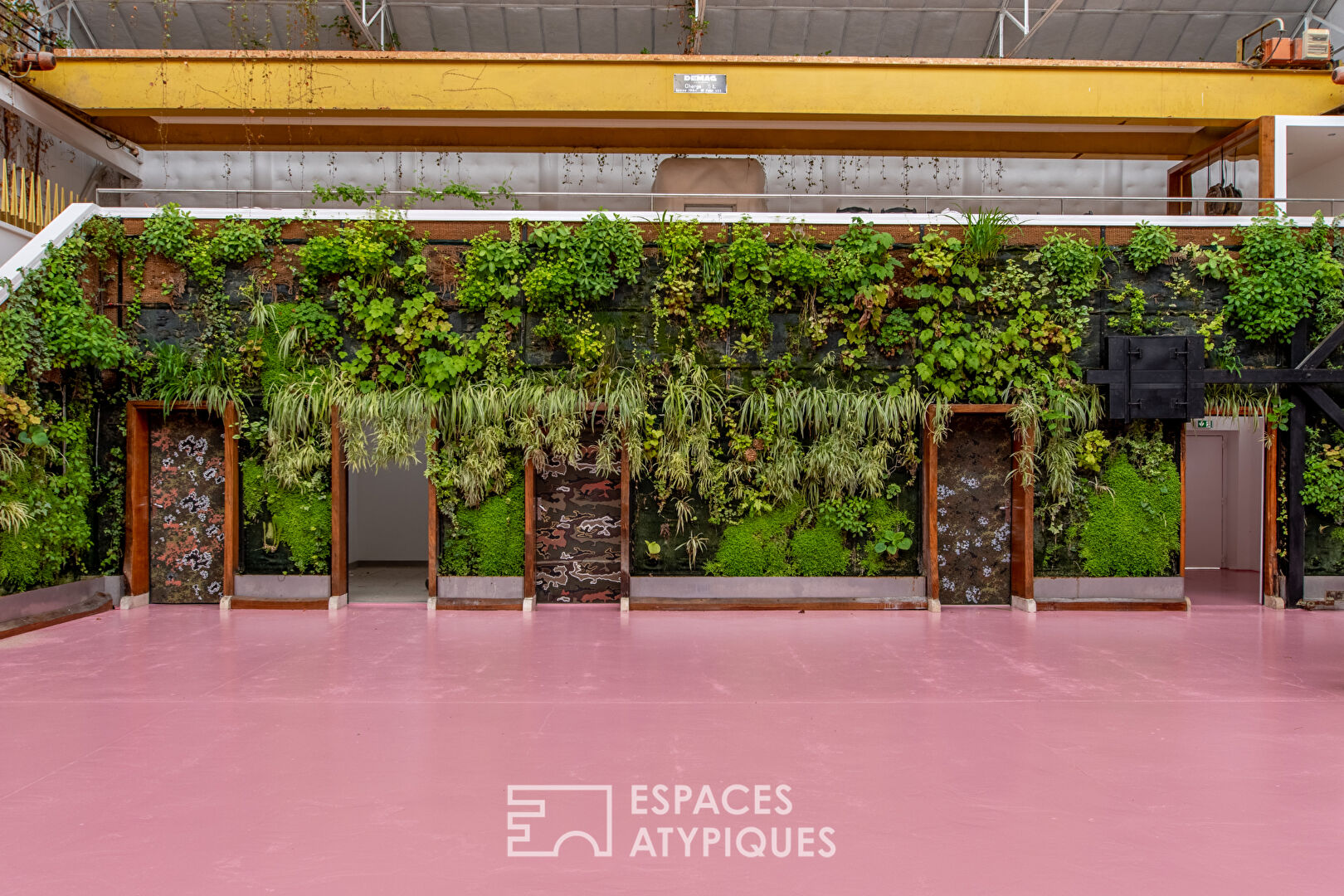 Loft industriel rose avec mur végétal